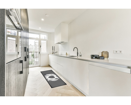 Moderne Küche mit Küchenläufer, weißen Schränken und Holzboden