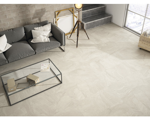 Helles Wohnzimmer mit Sofa, Tisch und Fliesenboden in Marmoroptik