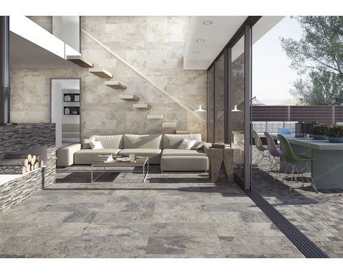 Beispiel eines Wohnbereichs mit Wand- und Bodenfliesen in Steinoptik, offen gestaltet mit Treppe und Zugang zum Außenbereich.