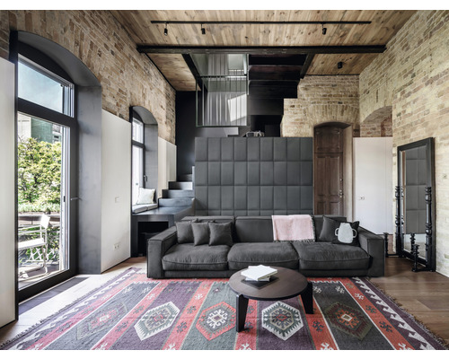 Wohnzimmer mit Sofa, Teppich und Ziegelwand