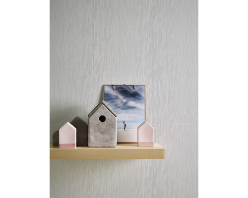 Dekorative Accessoires und eine Klemme mit einem Foto auf einem Regal vor einer Tapete