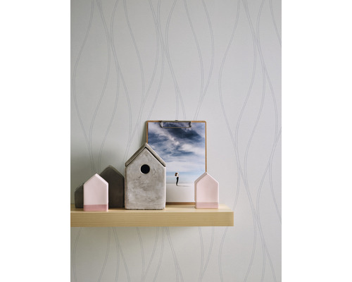 Helle Wand mit Tapetenmuster, Holzregal, Hausdekorationen und Bild auf einem Klemmbrett