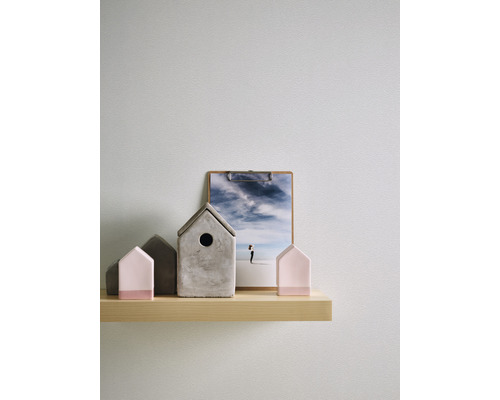 Dekorative Häuser und ein Klemmbrett mit einem Landschaftsbild auf einem Regal