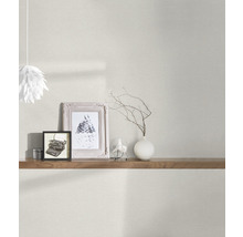 Wohnraumszene mit heller Wandtapete, Regal, Dekorationsartikeln und Lampe