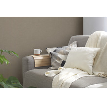 Graues Sofa mit Kissen, einer Tasse und einer Holzablage.