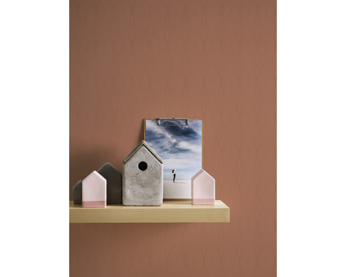 Dekorative Vogelhäuser aus Beton und Holz auf einem Regal mit einer Fotografie eines Strandes.