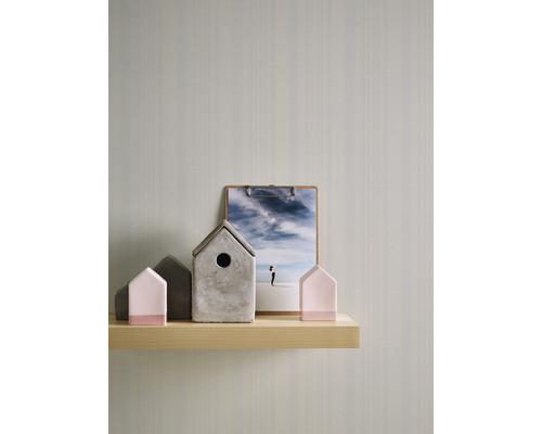 Dekorative Häuser und ein Klemmbrett mit einem Bild auf einem Regal.