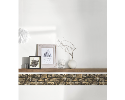 Wandgestaltung mit Steinimitat-Tapete, Regalbrett, Bildern und Dekoration für ein gemütliches Ambiente.
