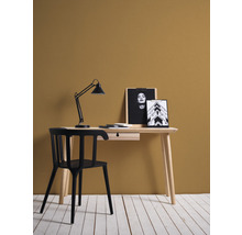 Schreibtisch mit Lampe, Stuhl und Dekoration im Zimmer