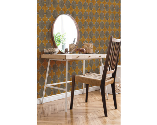 Gestrichene Wand mit gemusterten Tapeten hinter einem Holztisch mit Spiegel