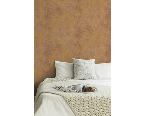 Schlafzimmer mit gemusterter Tapete hinter einem Bett