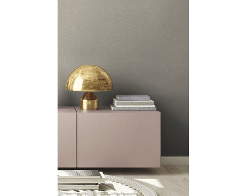 Innenraumansicht mit Kommode, Tischleuchte und dekorativen Büchern.