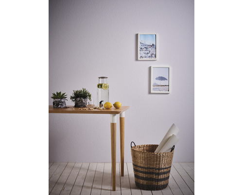 Helle Raumgestaltung mit Tisch, Dekoration, Bildern und Korb