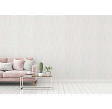 Wohnzimmer mit rosa Sofa, Tisch und gemusterter Tapete für eine helle und freundliche Atmosphäre.