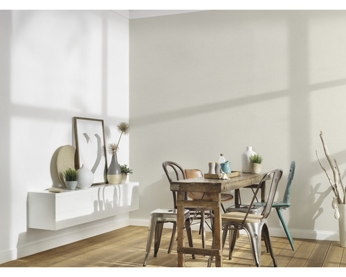 Helles Esszimmer mit Holztisch, Stühlen und dekorativen Elementen an der Wand