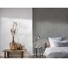 Schlafzimmer mit gemusterter Tapete, Bett, Lampe und Dekoration
