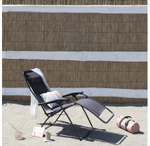 Strandszene mit einer Relaxliege, einem Handtuch, einer Tasche und Dekoartikeln