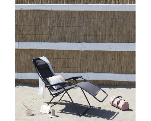 Strandszene mit einer Relaxliege, einem Handtuch, einer Tasche und Dekoartikeln