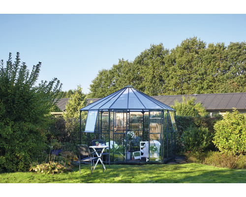 Gewächshaus im Garten mit Gartenmöbeln und Pflanzen