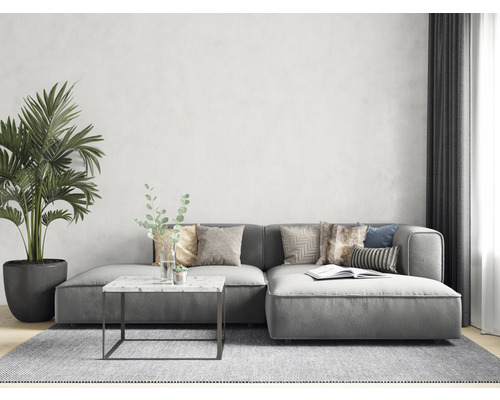 Wohnzimmer mit grauem Ecksofa, Couchtisch mit Marmorplatte und Zimmerpflanze