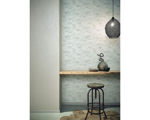 Wohnraum mit gemusterter Tapete, Holzbord, Hocker und Dekoration