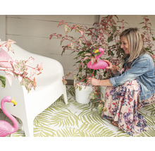 Dekorierte Veranda mit Frau, Gartenflamingo, Pflanze, Blumentopf, Teppich und Stuhl