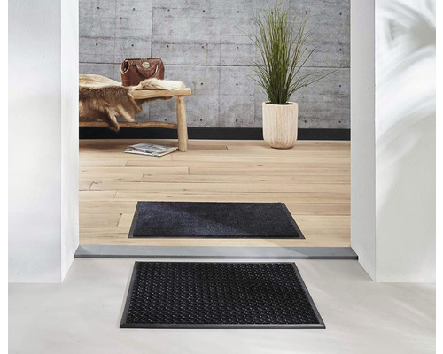 Szene mit Fußmatten vor einem Hauseingang.