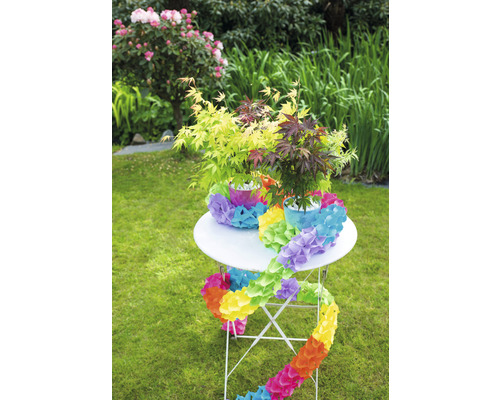 Dekorierter Gartentisch mit Ahornpflanzen und Blumengirlande