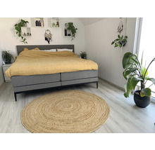 Schlafzimmer mit Bett, Teppich und Pflanzen