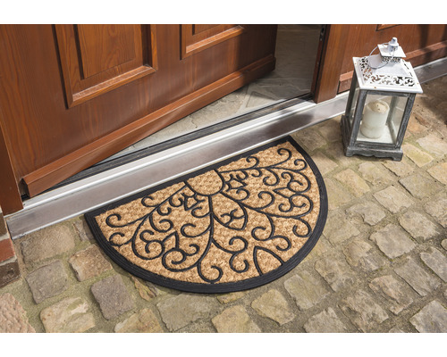 Halbrunde Fußmatte aus Kokosfaser mit floralem Muster vor einer Haustür