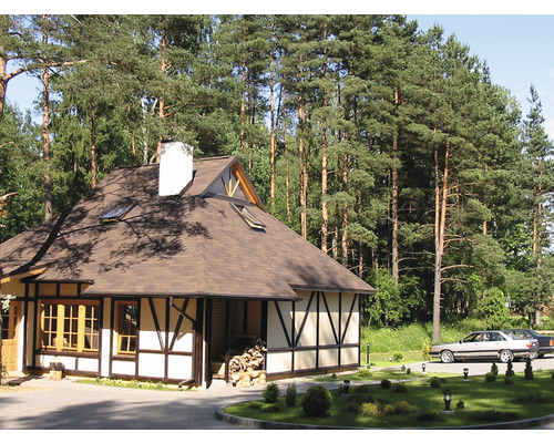 Fachwerkhaus mit Satteldach und Dachfenstern in waldreicher Umgebung