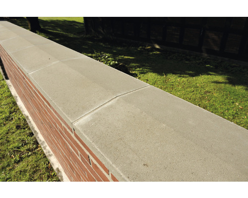 Eine Mauer mit Mauerabdeckung aus Beton.