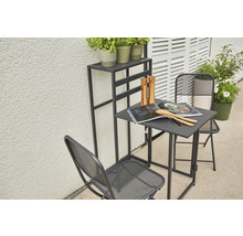 Gartenszene mit Tisch, zwei Stühlen und einem Pflanzenständer auf einer Terrasse.