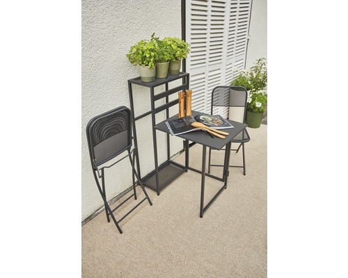 Gartenszene mit Klapptisch, Klappstühlen und Pflanzenregal auf dem Balkon