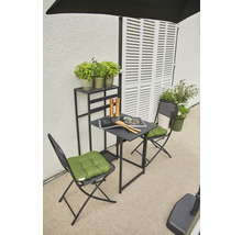 Gartenszene mit Tisch, Stühlen, Pflanzen und Regal vor einer Wand