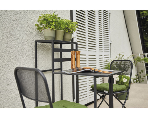 Gartenszene mit Tisch, Stühlen und Pflanzenregal auf einem Balkon