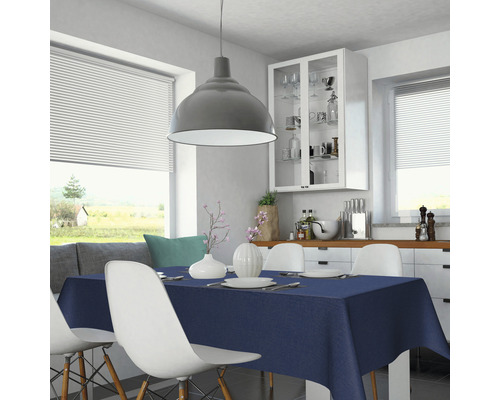 Esstisch mit dunkelblauer Tischdecke in einer hellen Küche.