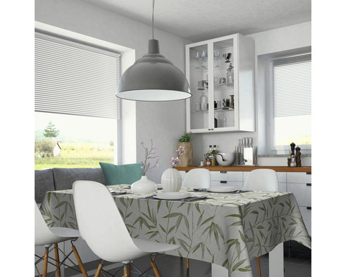 Helles Esszimmer mit Tisch, Stühlen und Tischdecke mit Pflanzenmuster