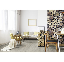 Wohnzimmer mit Sofa, Sessel, Holztisch, Brennholzregal und Holzmuster-Tapete