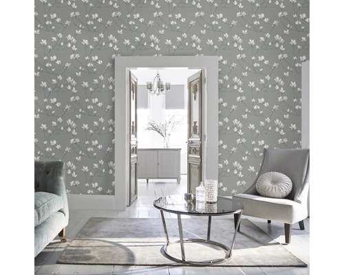 Wohnzimmer mit grauer Blumentapete, Sessel und Tisch