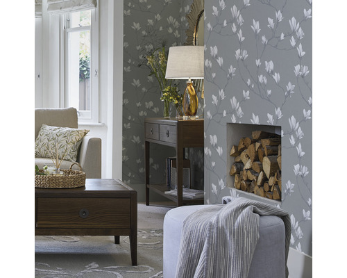 Wohnzimmer mit gemusterter Tapete, Couch, Tisch und Kaminholz