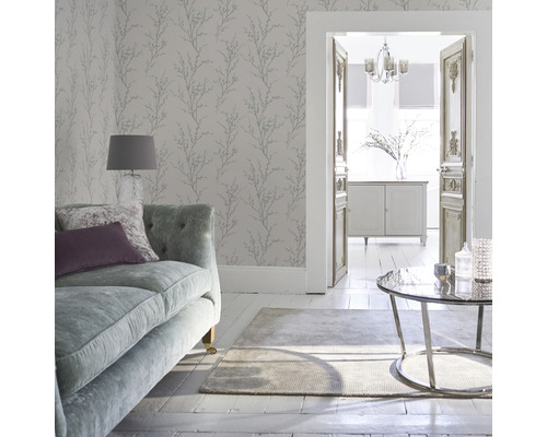 Wohnzimmer mit Sofa, Teppich, Tisch und Wandtapete mit Pflanzenmuster