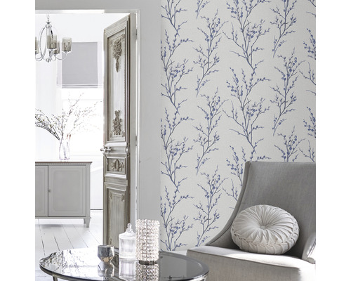 Wohnzimmer mit floral gemusterter Tapete, Sessel und Tisch