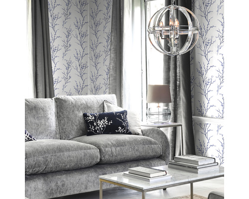 Wohnzimmer mit grauer Couch, Couchtisch, Lampe und Tapete mit floralem Muster