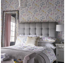 Helles Schlafzimmer mit Blumenmuster Tapete, gepolstertem Kopfteil und Spiegel