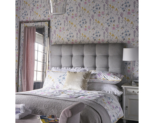 Helles Schlafzimmer mit Blumenmuster Tapete, gepolstertem Kopfteil und Spiegel