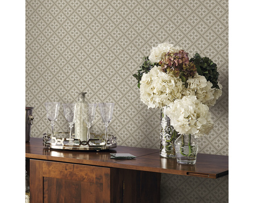 Detailansicht einer beigefarbenen, gemusterten Tapete mit Blumen, Gläsern und Getränken auf einem Tisch