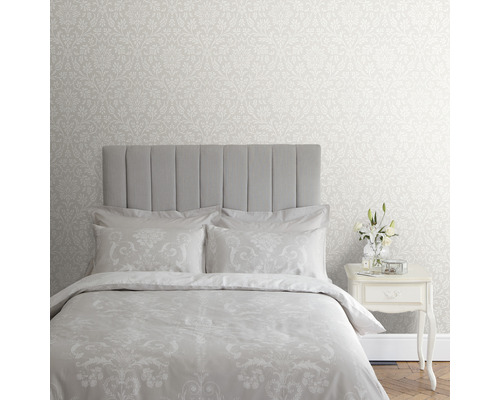 Schlafzimmer mit floral gemusterter Tapete, Bett und Nachttisch