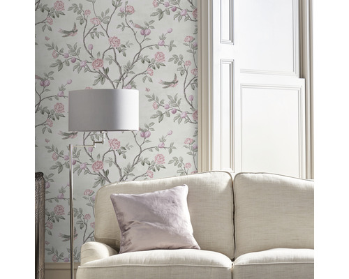 Wohnzimmer mit floral gemusterter Tapete, Sofa und Stehlampe