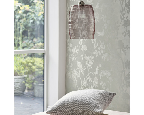 Hängelampe und Tapete mit Blumenmuster in einem hellen Raum.